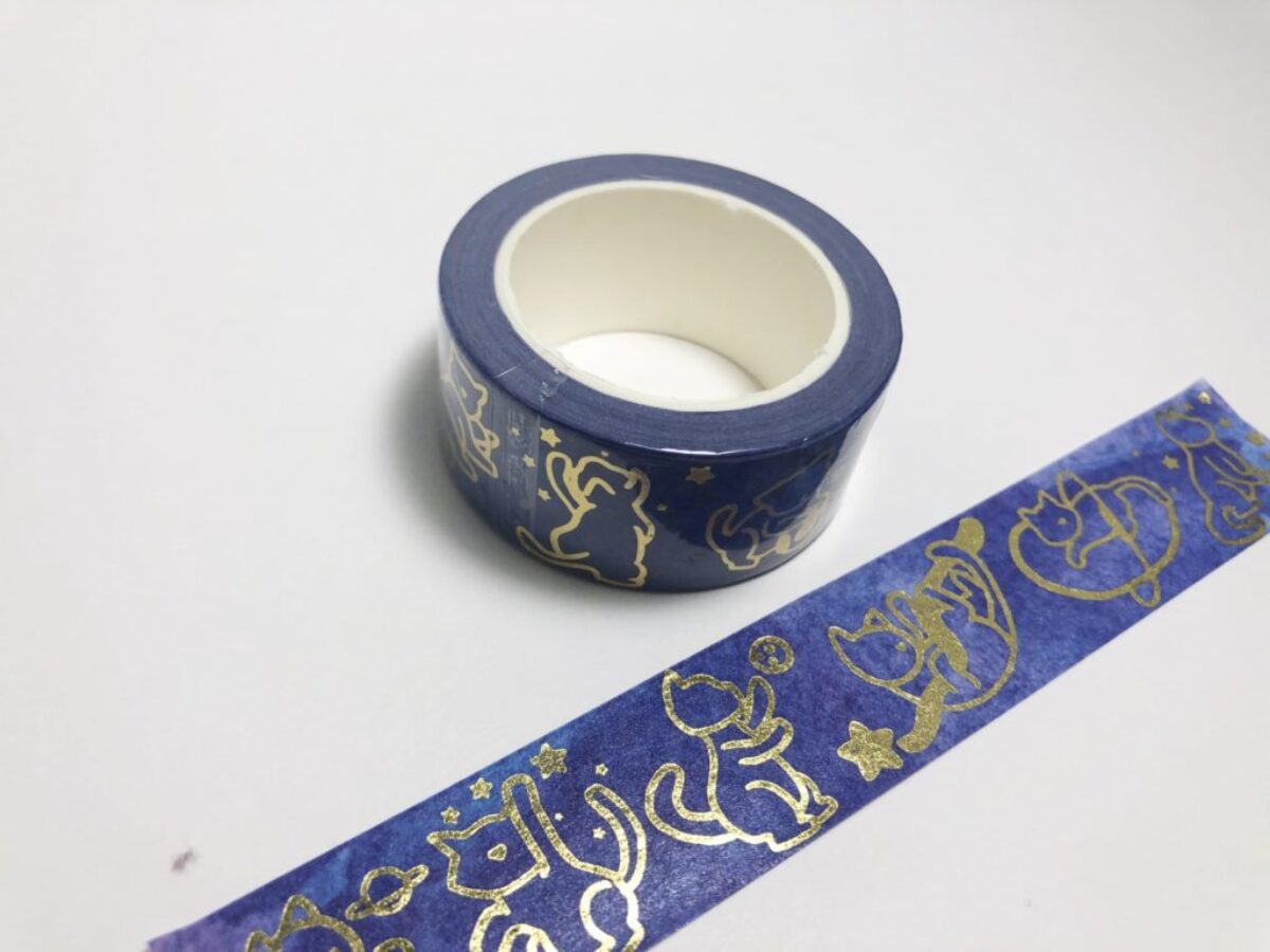 Washi tape featuring gold cats playing in space.