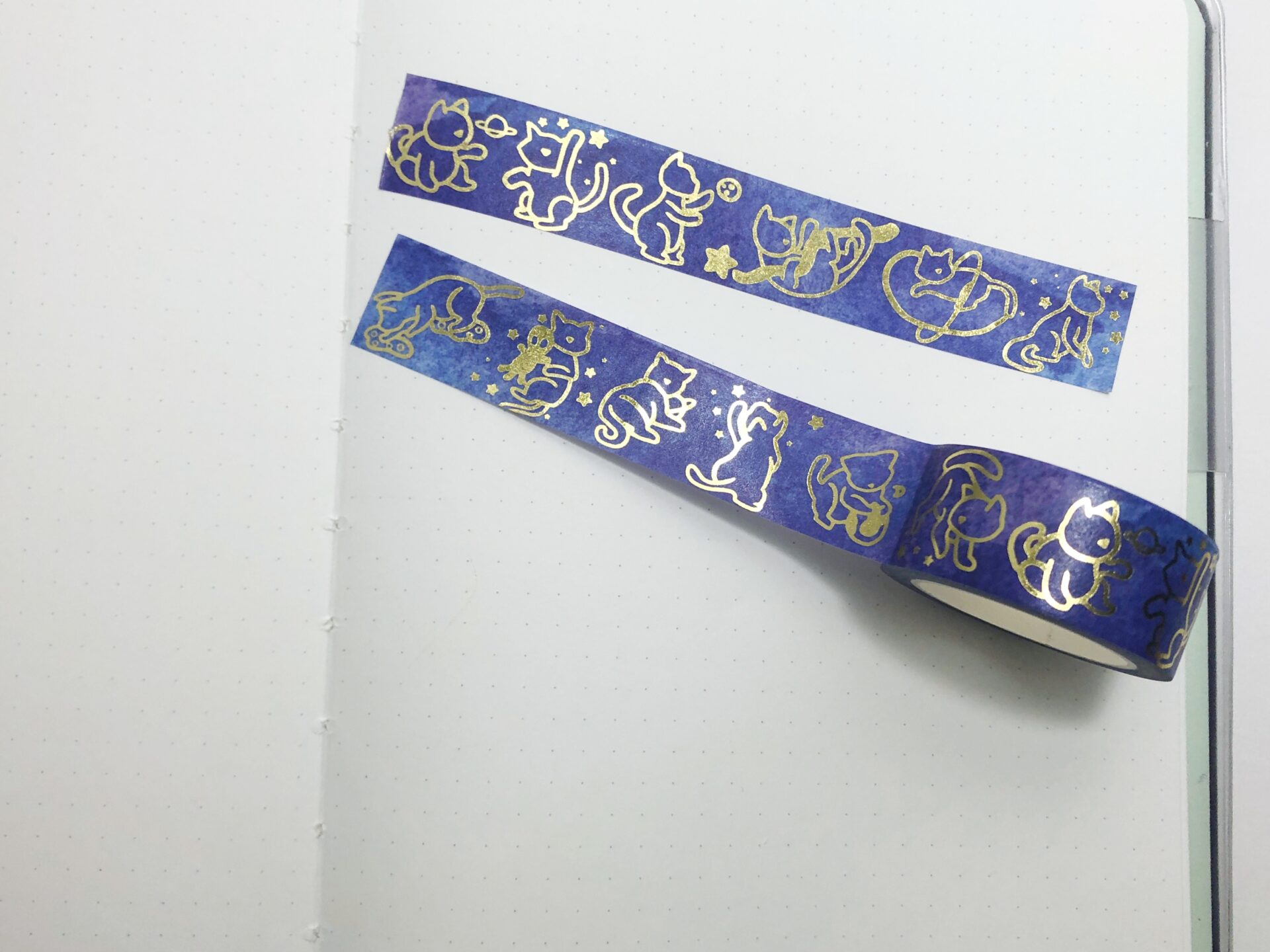 Washi tape featuring gold cats playing in space.